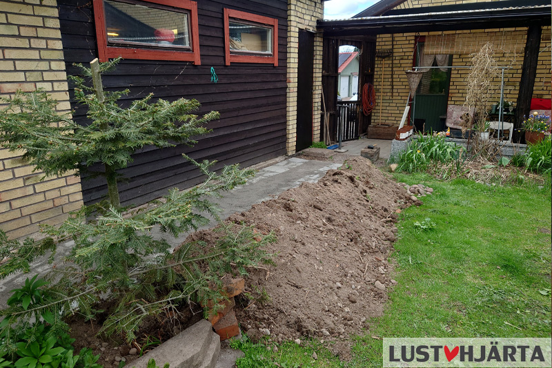 I trädgården - jordhög efter att vi lagt plattor vid väggen